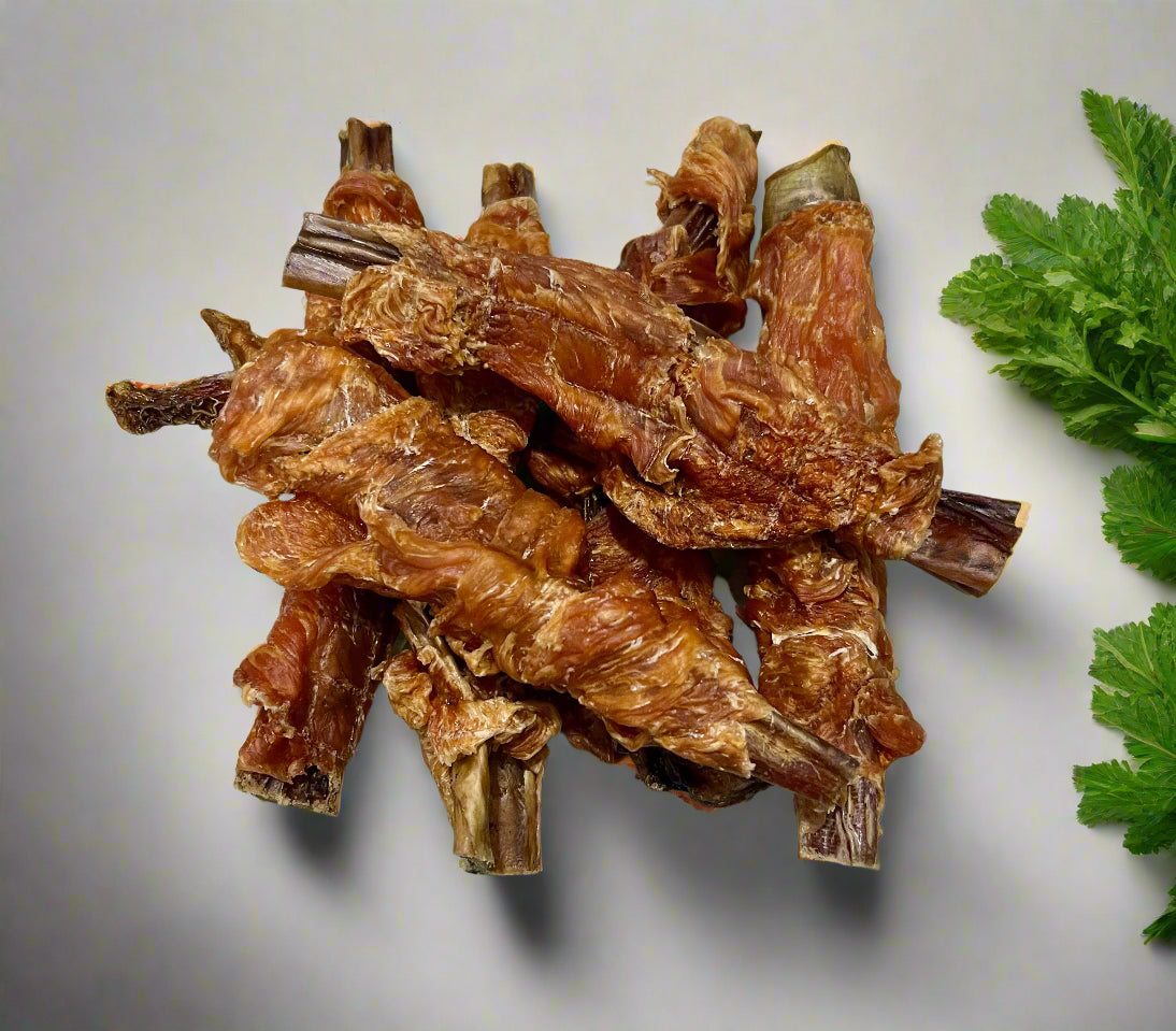 chicken wrapped bully sticks on a bench with green leaves